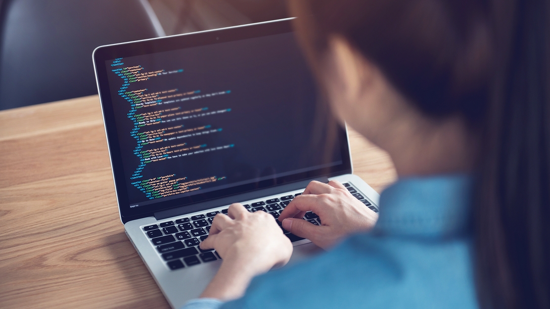 女性がPCでコードを書いている様子