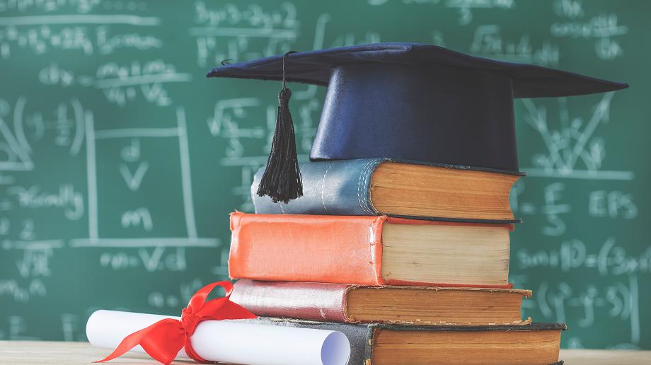 積み重なった本の上に置かれた学位帽