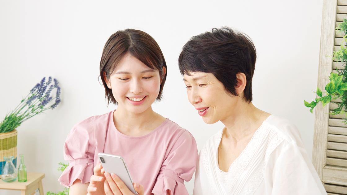 2人の女性が携帯を見ている